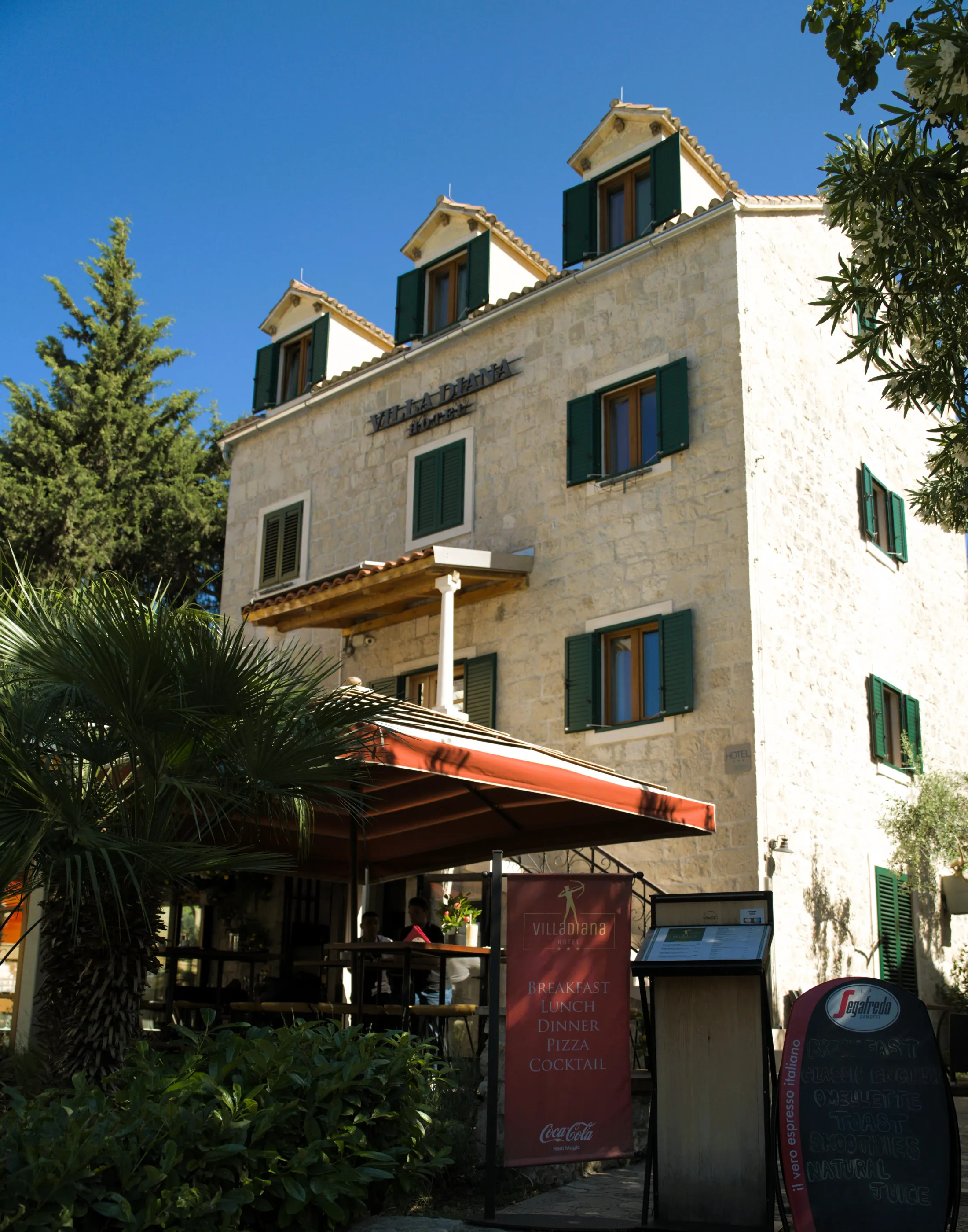 The Villa Diana stone house with its covered terrace and palms, Pizzeria Villa Diana, Lučac, Split