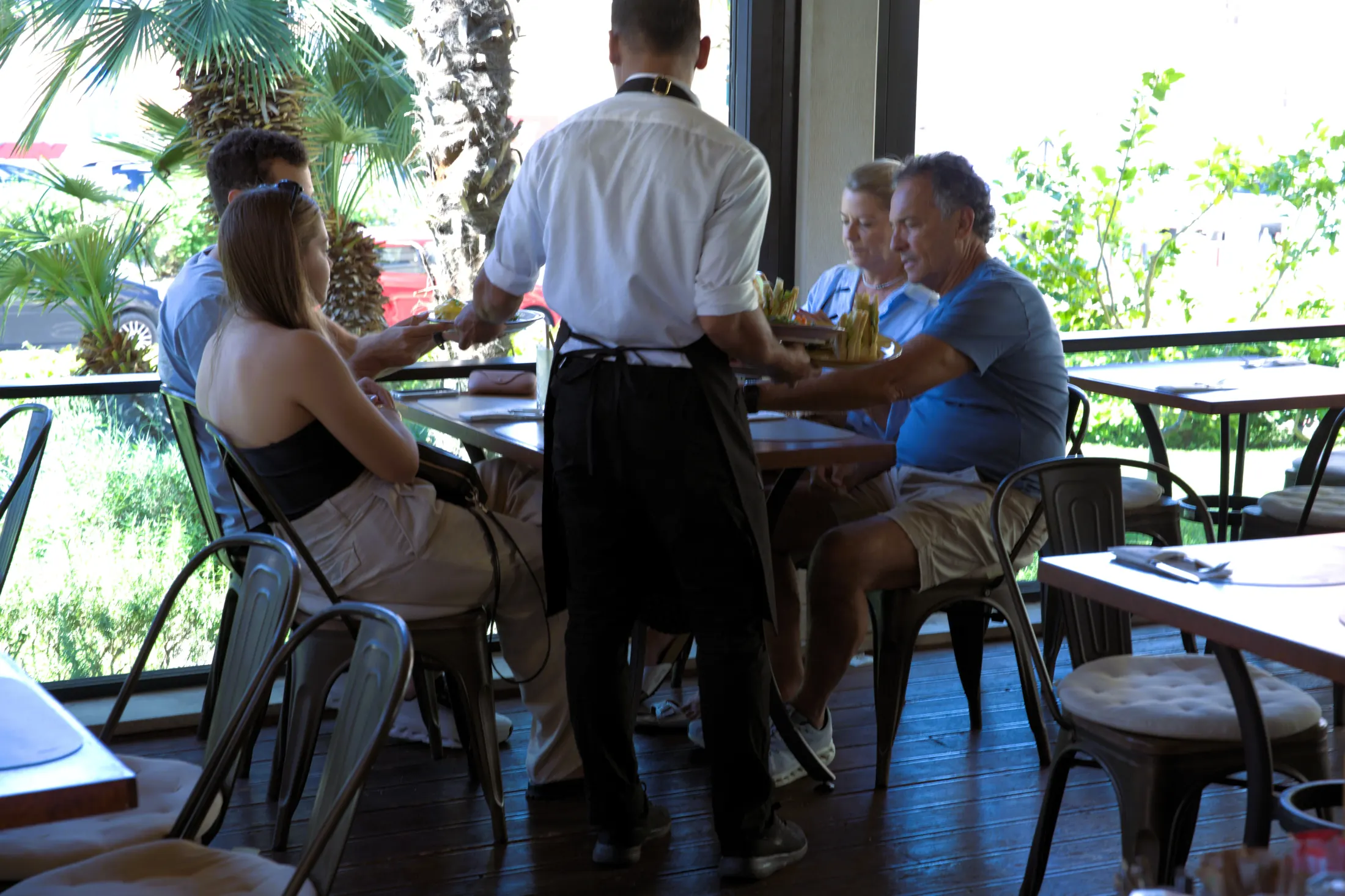 A waiter serving guests at the tables by the garden, Pizzeria Villa Diana, Lučac, Split