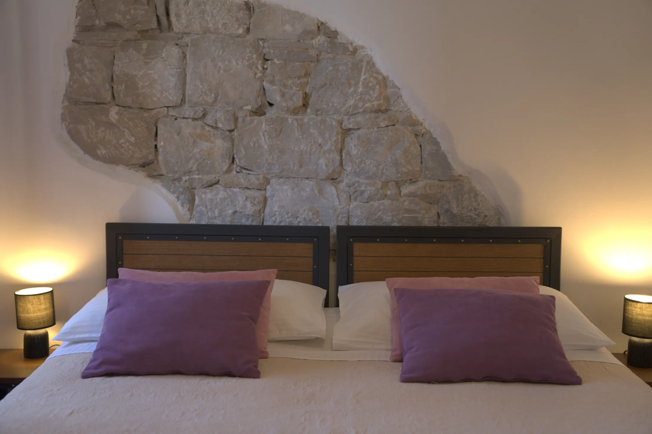 The headboards with bedside lamps against the exposed stone wall, Hotel Villa Diana, Lučac, Split