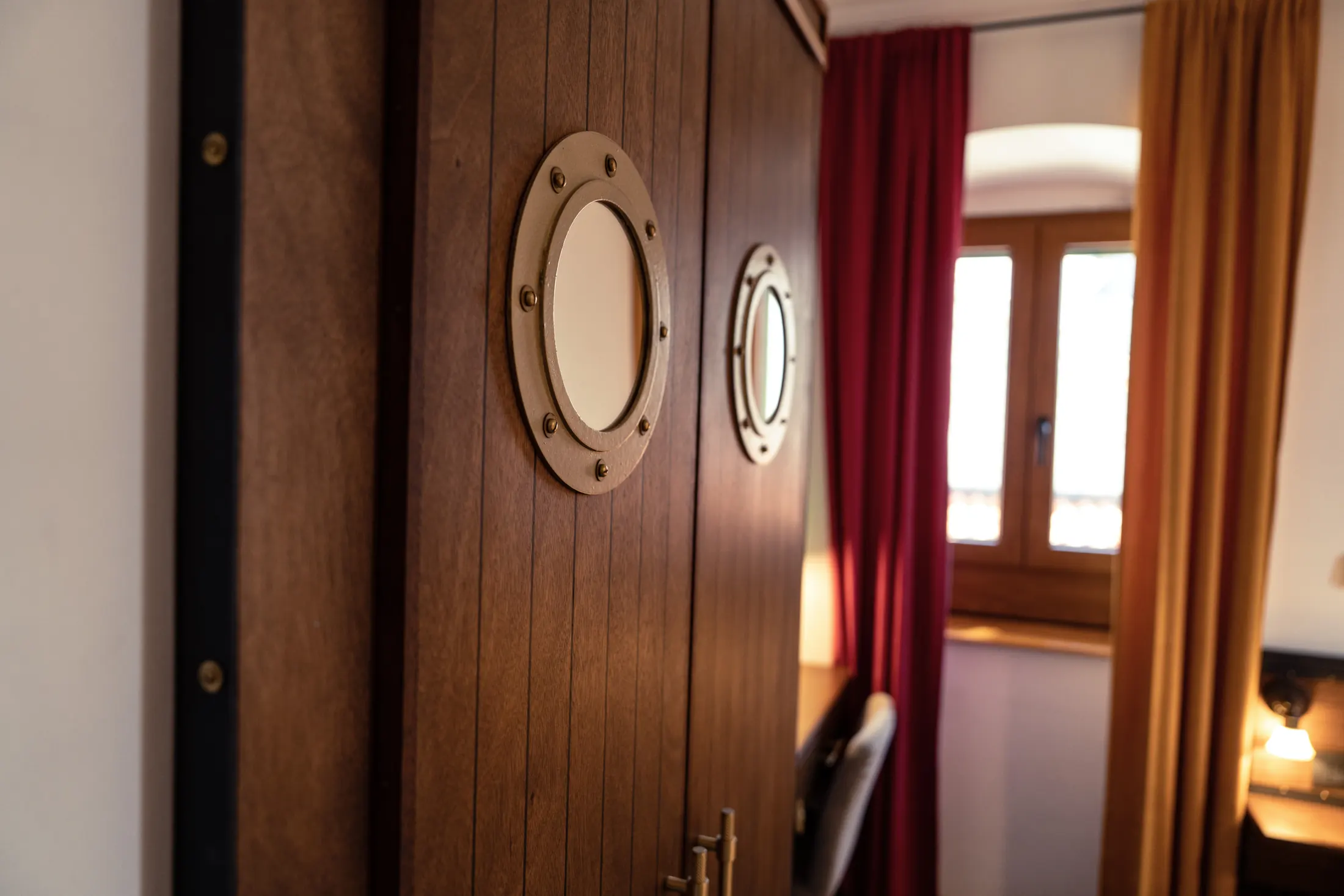 The wardrobe with porthole windows, beside the window with burgundy curtains, Hotel Villa Diana, Lučac, Split