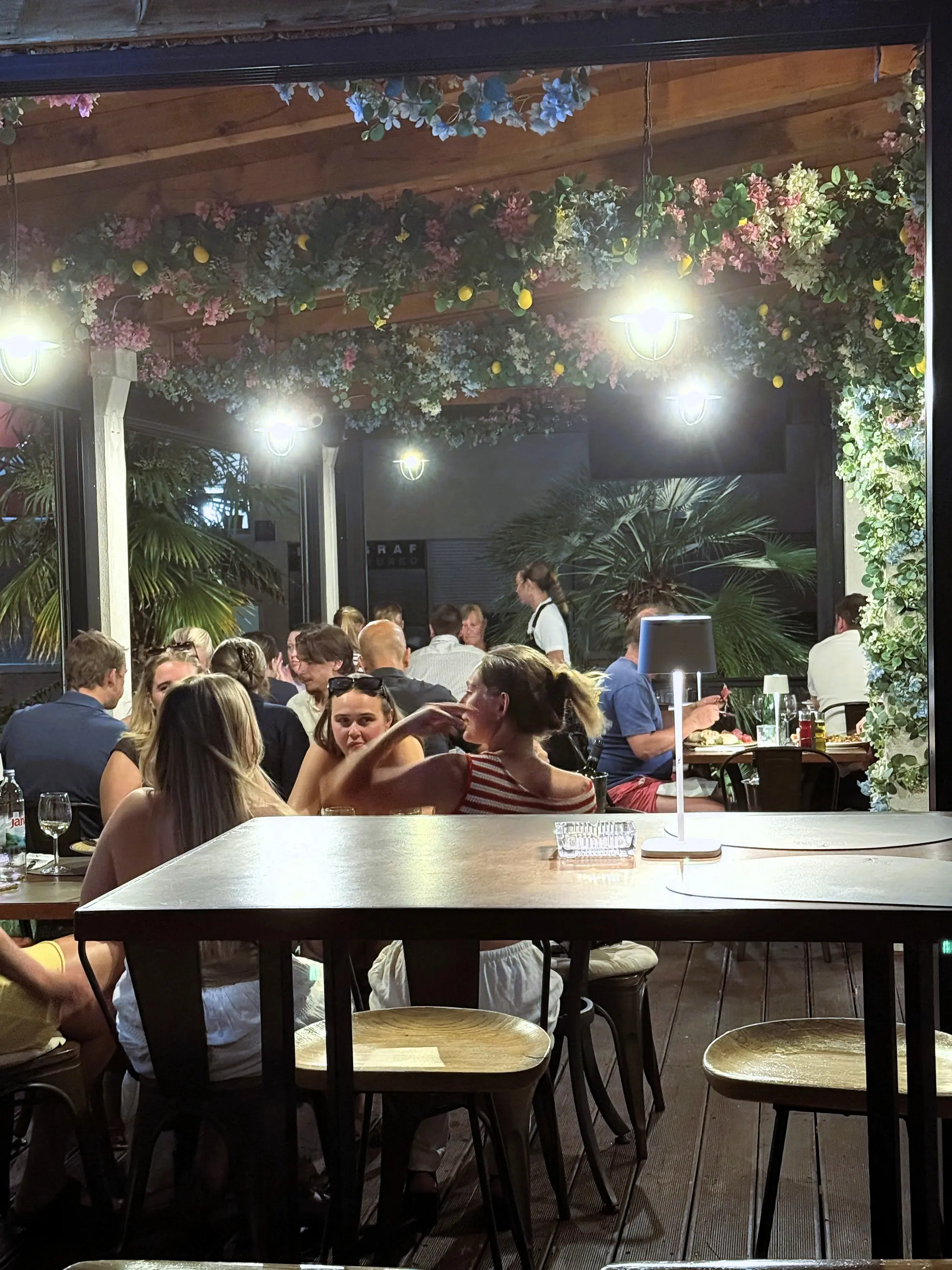 Terasa puna gostiju pod svjetlima, navečer, Pizzeria Villa Diana, Lučac, Split